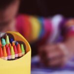 Crayons beside child coloring