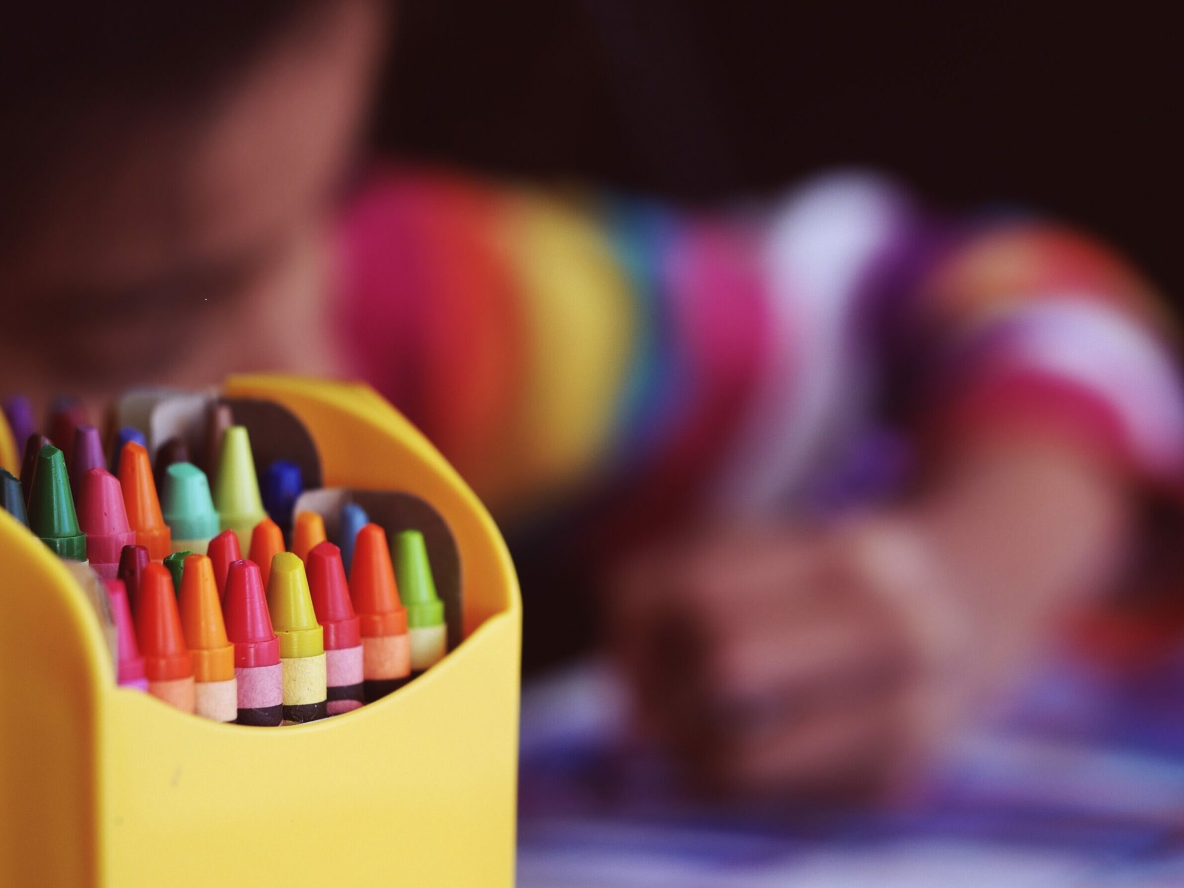 Crayons beside child coloring