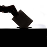 Person dropping paper on box