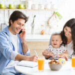 Busy guy talking with colleagues on phone, working from home