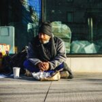 A homeless man eats breakfast on the street on Upper East Side of Manhattan.