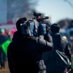 man carrying professional camera