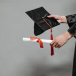 Photo of person holding graduation cap and diploma