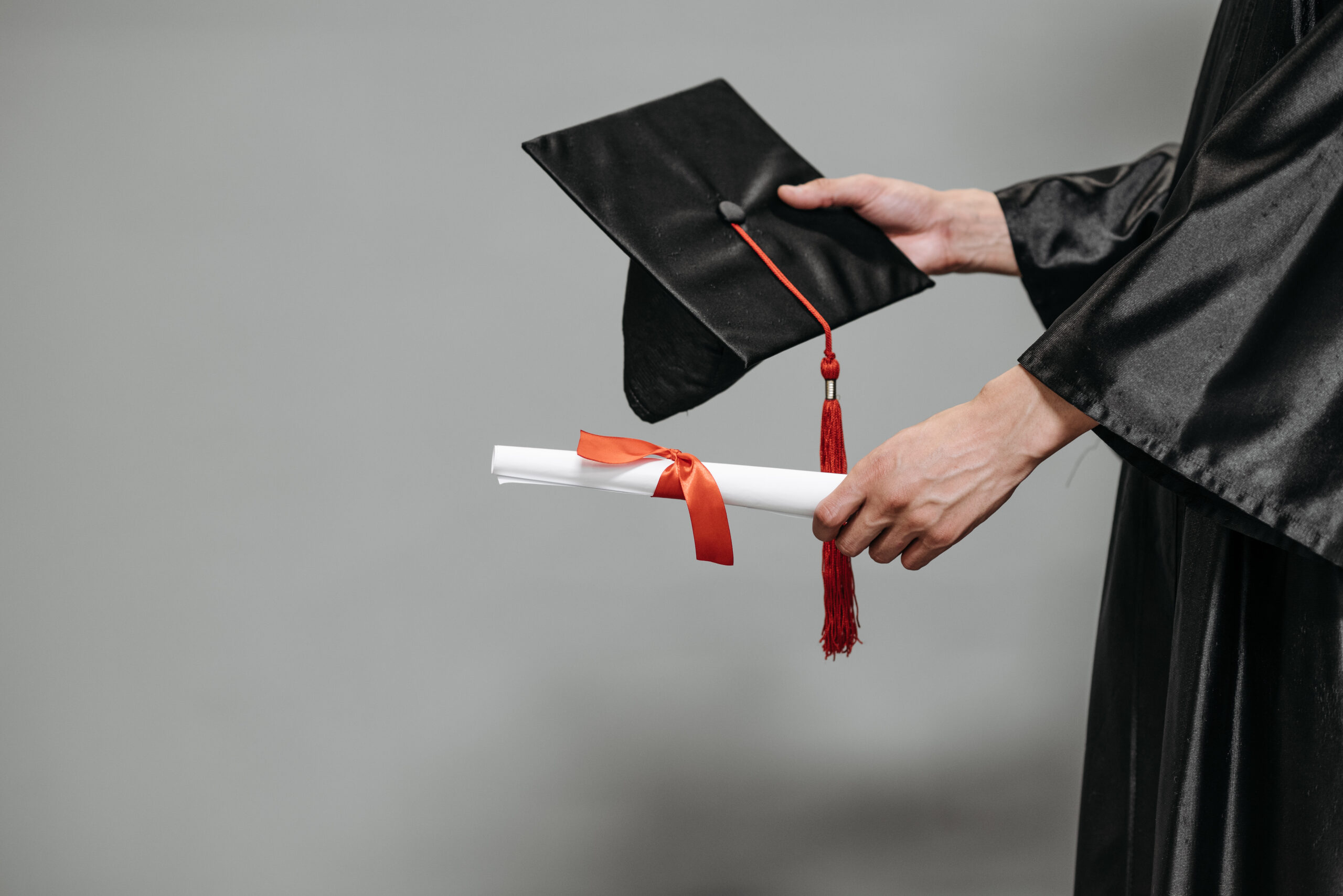 Photo of person holding graduation cap and diploma