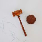 A wooden gavel on a white marble backdrop.