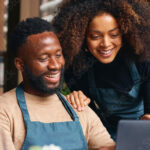 Small business owners using laptop in restaurant