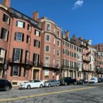 cars parked in front of brown concrete building during daytime