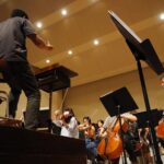 man in black t-shirt playing violin