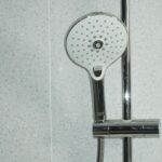 stainless steel shower head on white ceramic tiles