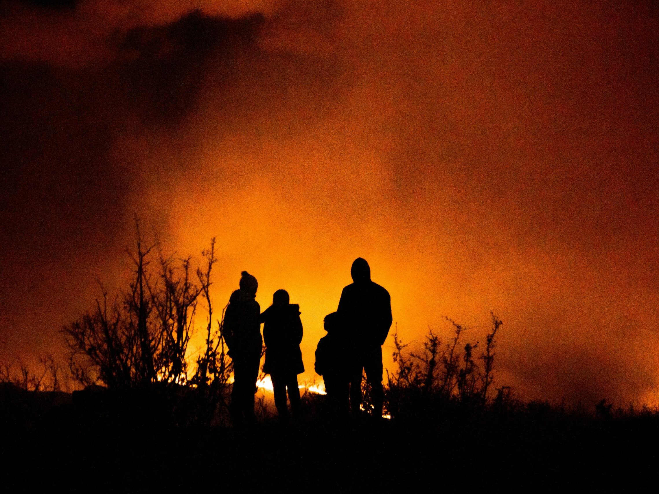 Family watching a wildfire in the distance in the summer of 2020.