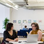 Group of plus size employees in a modern, bright open office working on computer