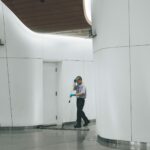 man cleaning on floor beside white wall