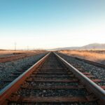 brown train rail under blue sky during daytime