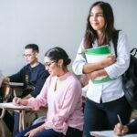 woman carrying white and green textbook