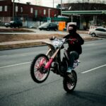 woman in black jacket riding red sports bike on road during daytime