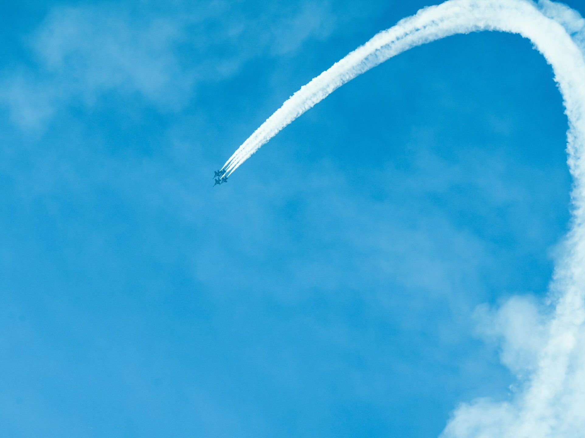 a plane flying in the sky leaving a trail of smoke