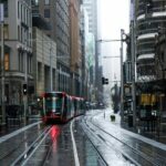 red and black tram on road between buildings during daytime