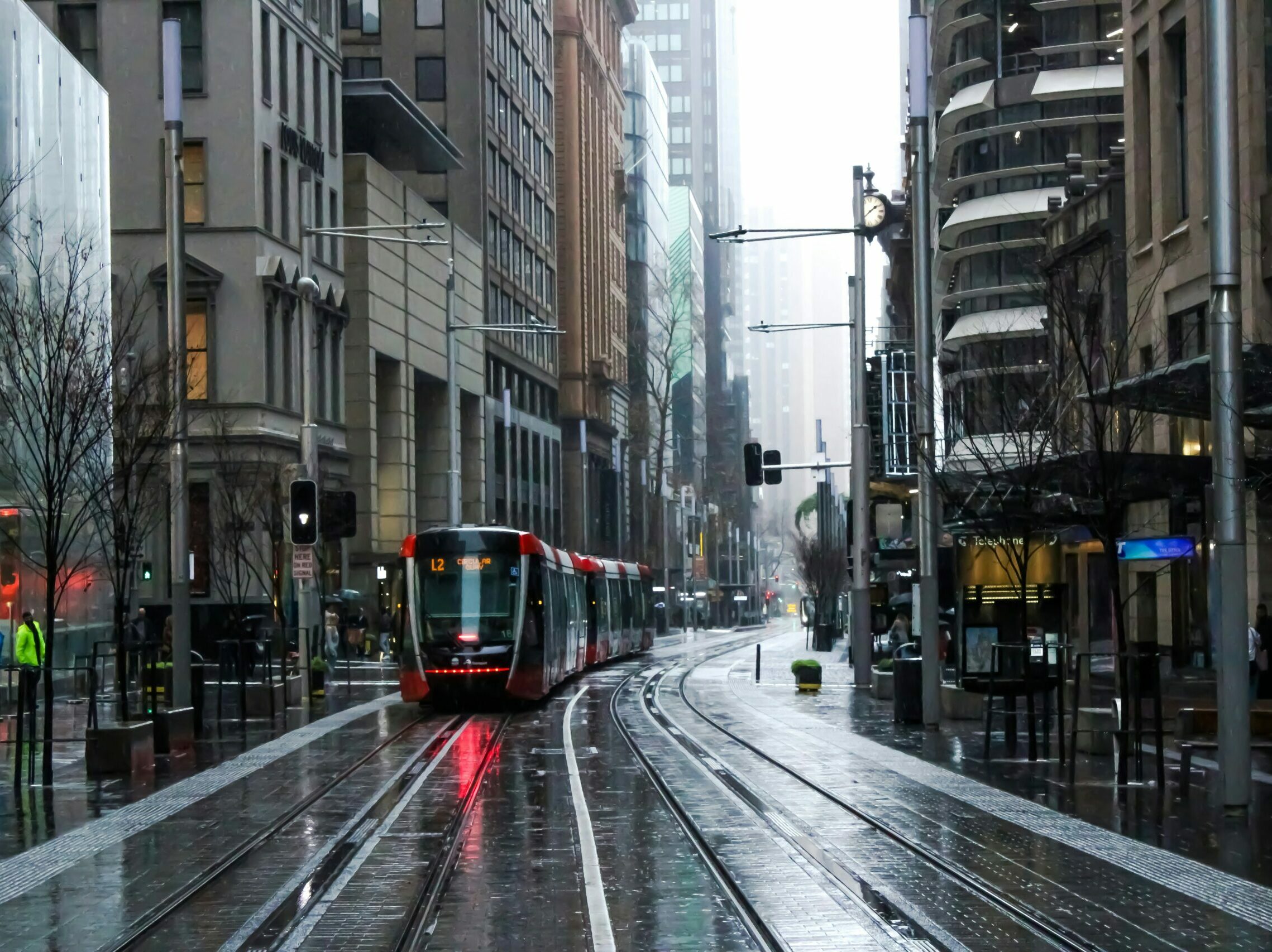 red and black tram on road between buildings during daytime