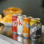 two coca cola cans on stainless steel table