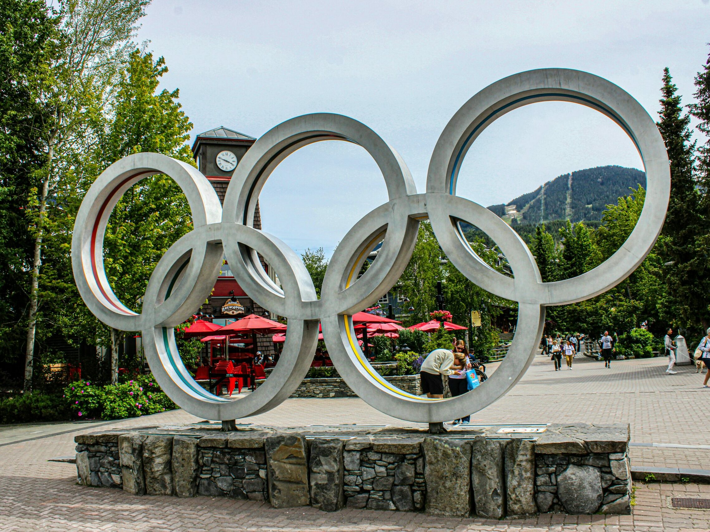 A statue of the olympic rings in a park