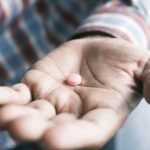 Close up of man hand holding pills with copy space .