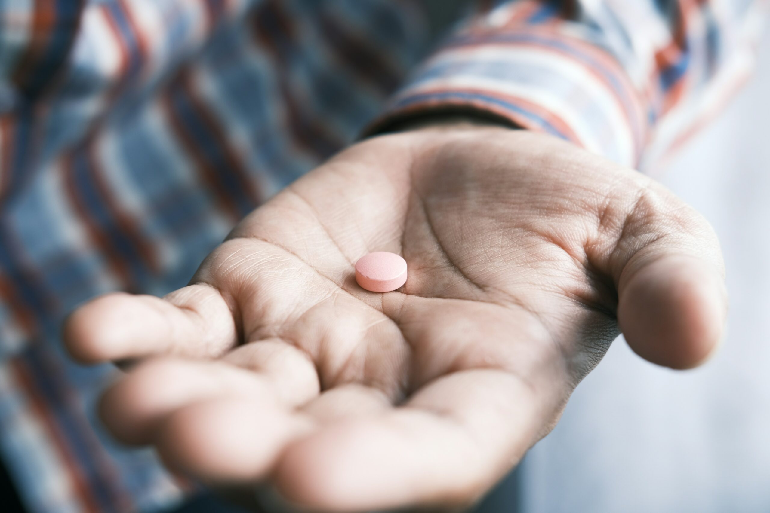 Close up of man hand holding pills with copy space .