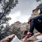 man sitting on brown rock formation