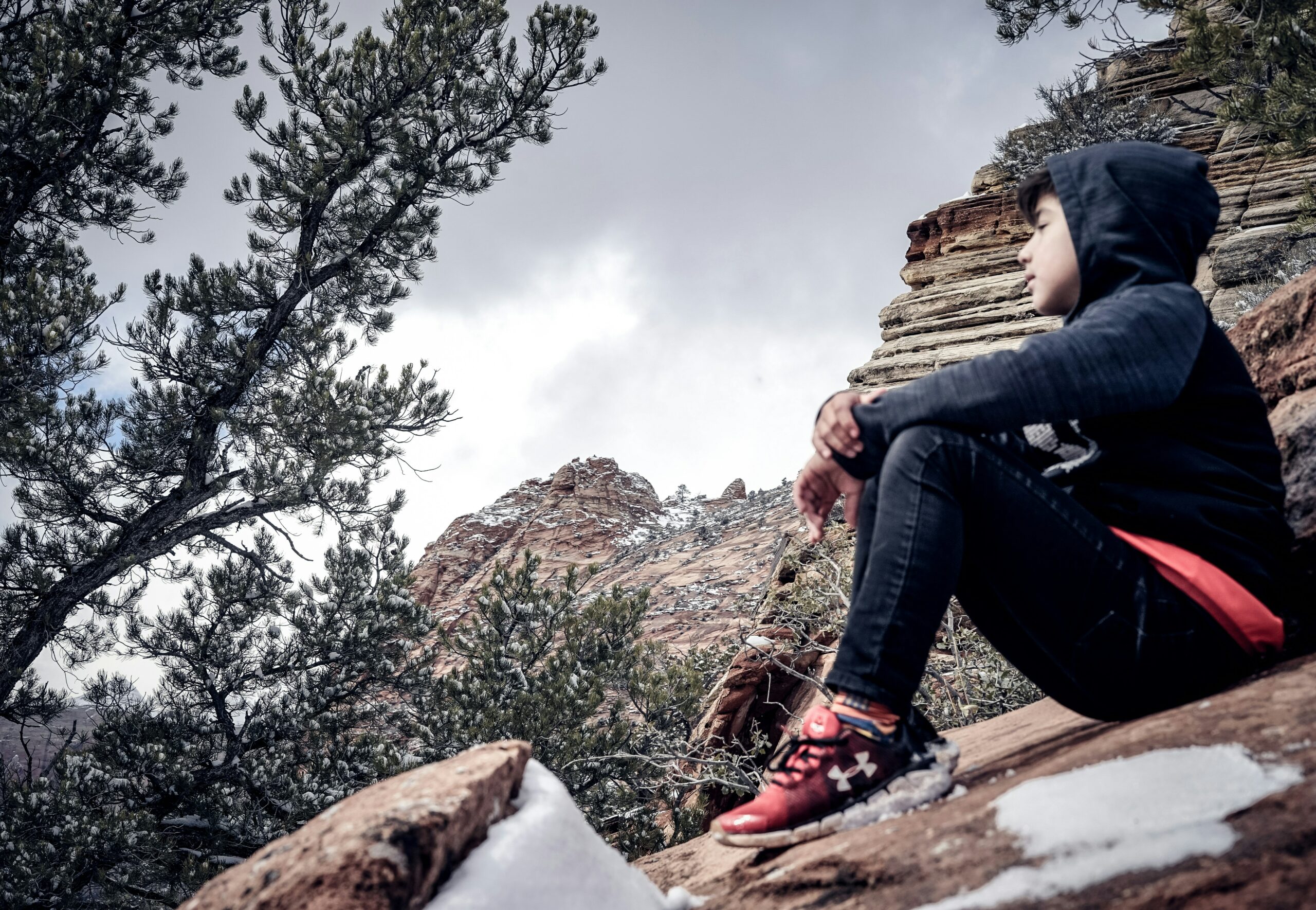 man sitting on brown rock formation