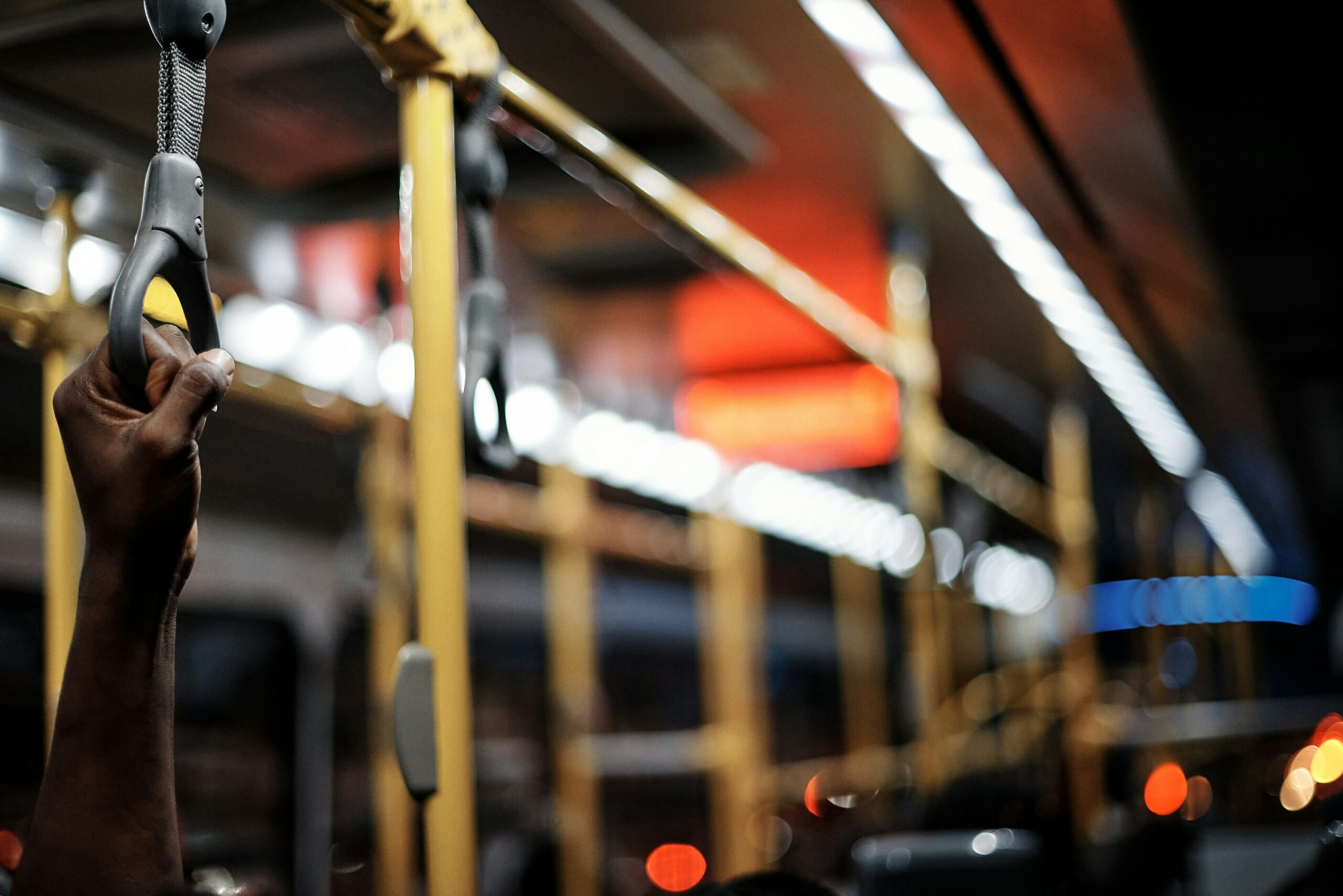 Lagos, Nigeria - 30.11.2021: Shots of the interiors, Close up of hand holding a handgrip, and a watch your step sign on a BRT, a mass transit system in Lagos, Nigeria.