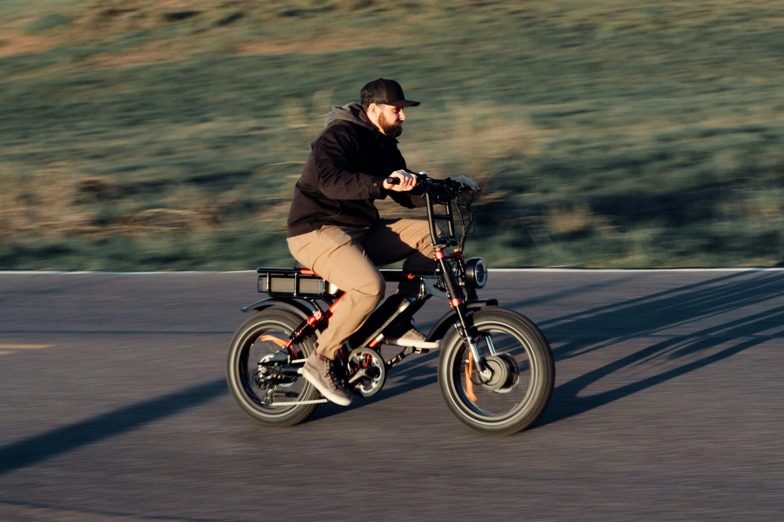 Male model riding ebike during golden hour sunset in the mountains.