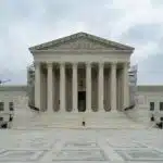 A large building with columns and pillars on a cloudy day