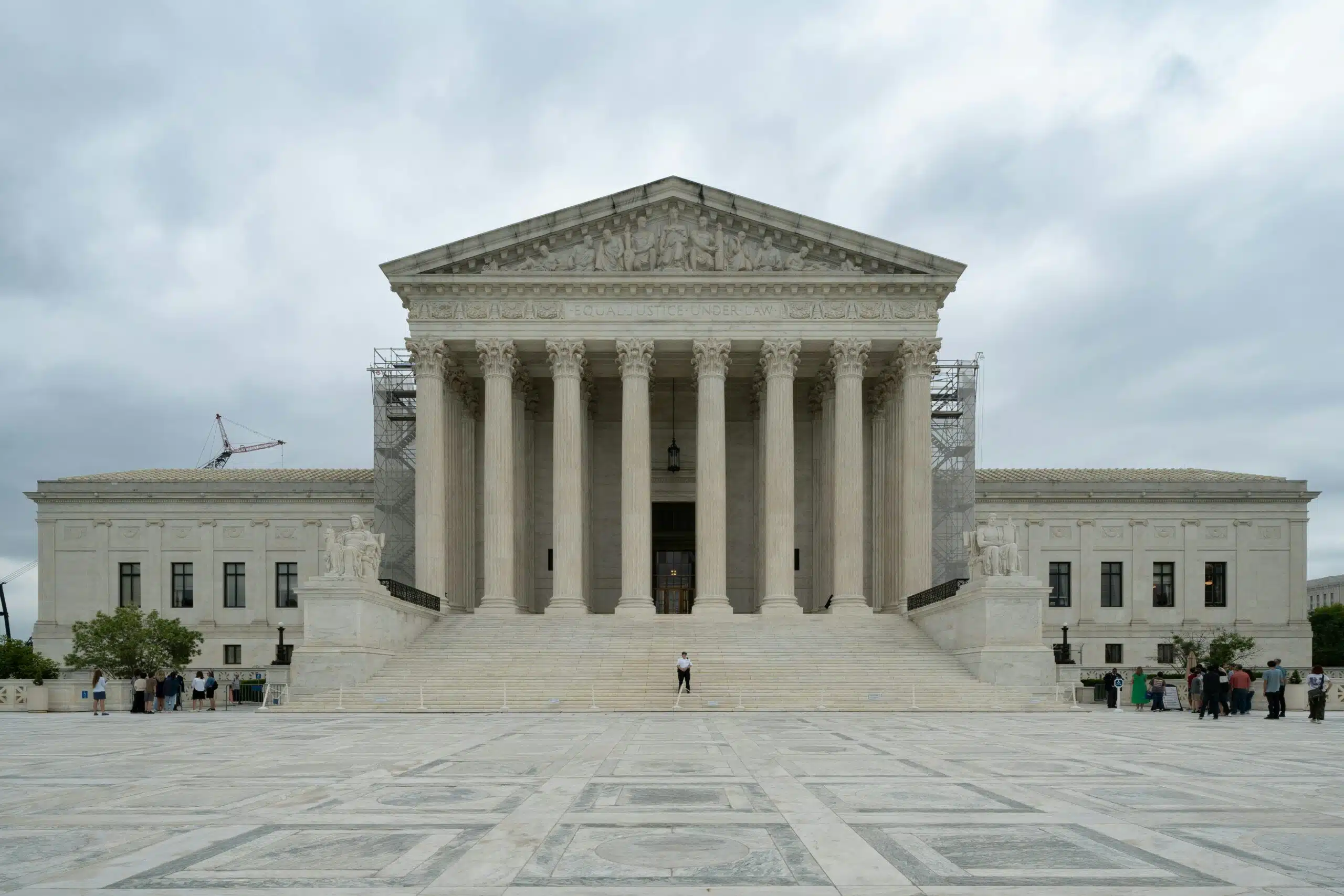 A large building with columns and pillars on a cloudy day