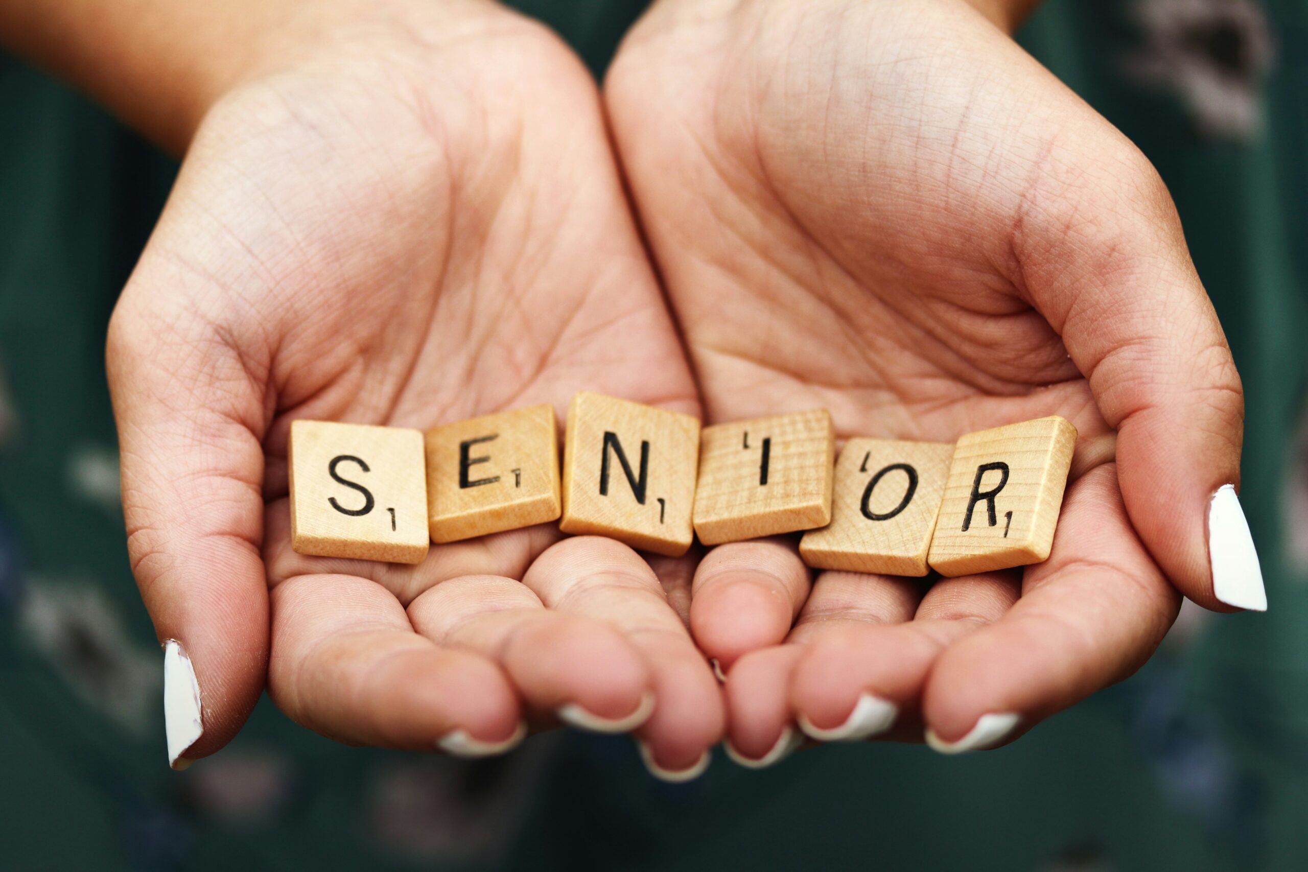 Macro shot of teen girl with manicured fingernails holding scrabble letters spelling the word SENIOR in the palms of her cupped hands. This was my first shot during a senior portrait session a few years ago and taken spur of the moment in the parking lot at Kohler-Andrae State Park in Sheboygan, Wisconsin.